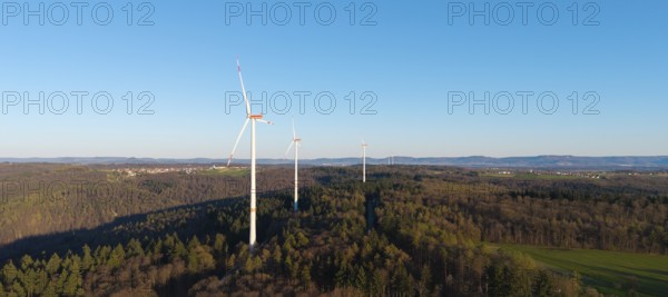 Wind turbines on a wooded hill under a clear blue sky, near Schorndorf im Remstal, Baden-Württemberg, Germany