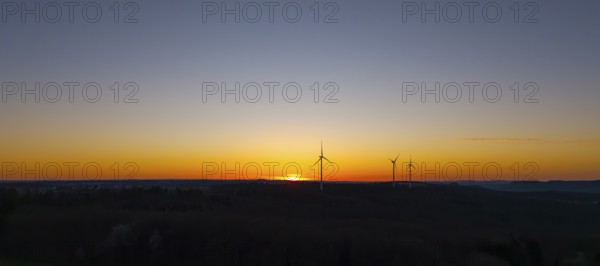 Silhouette of wind turbines at sunset in the distance, near Schorndorf im Remstal, Baden-Württemberg, Germany