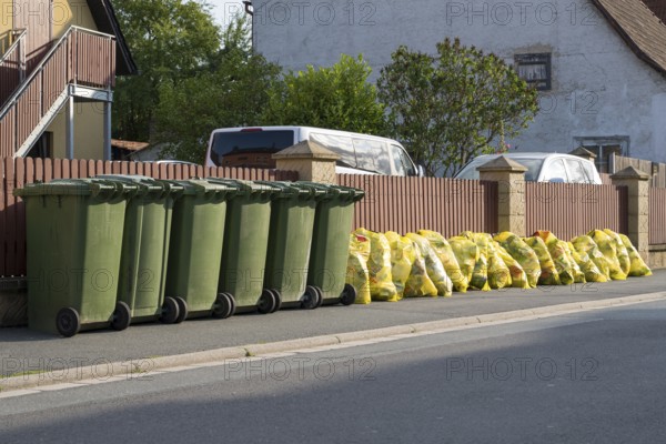 Green bins for organic waste and yellow bags for plastic waste at the roadside, waste separation, Bad Staffelstein, Upper Franconia, Franconia, Bavaria, Germany