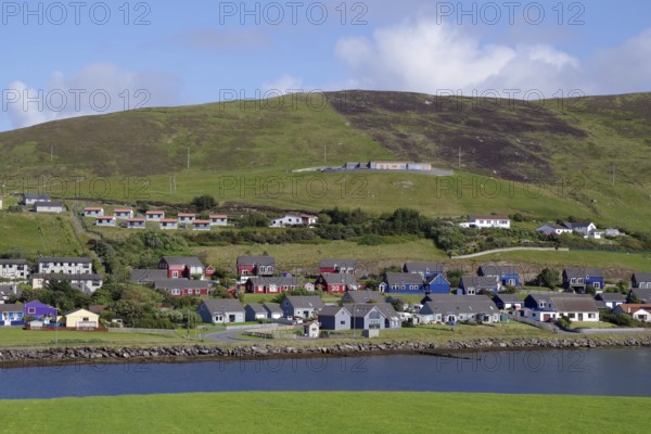 A picturesque village with colourful houses on the coast and green hills, Scalloway, Shetland Islands, Scotland, United Kingdom