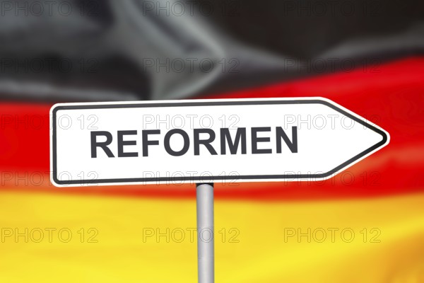 (Photomontage) Directional arrow with the inscription REFORMEN in front of a German flag