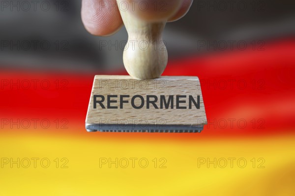 (Photomontage) Stamp with the inscription REFORMEN in front of a German flag