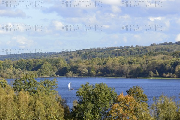 View of the Möhnesee with sailing boat, autumn atmosphere, blue cloudy sky, Möhnetalsperre, North Rhine-Westphalia, Germany