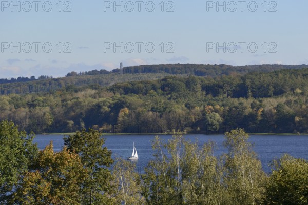 View of the Möhnesee with sailing boat and the Möhnesee tower, autumn atmosphere, blue sky, Möhnetalsperre, North Rhine-Westphalia, Germany