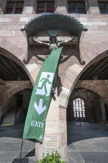 Exit sign in front of a Christ cross in the courtyard of the Heilig Geist Spital, Nuremberg, Middle Franconia, Bavaria, Germany