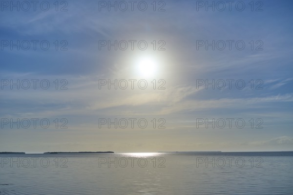 Sunbeams illuminate the calm ocean surface under a clear sky, Flamingo, Everglades National Park, Florida, USA