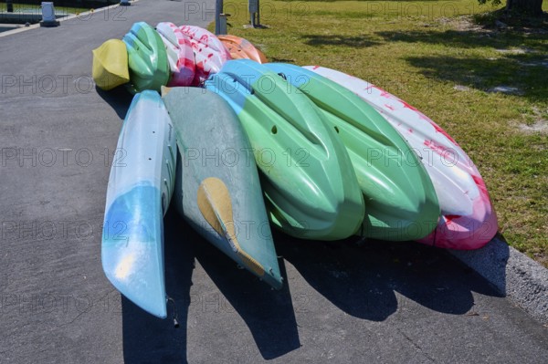 Stack of colourful kayaks on a paved surface, Flamingo, Marina, Everglades National Park, Florida, USA