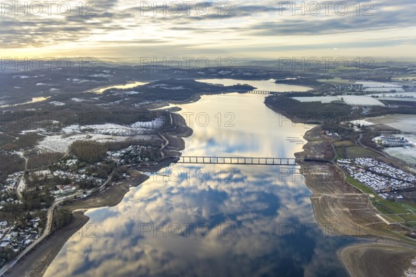 Aerial view of Lake Möhnesee in winter with snow and reflections of clouds on the water surface at low tide in Körbecke in Möhnesee in Sauerland in North Rhine-Westphalia, Germany, Sauerland, Europe, aerial view, birds-eyes view, aerial photography, aerial photography, overview, bird's eye view