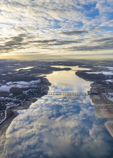 Aerial view of Lake Möhnesee in winter with snow and reflections of clouds on the water surface at low tide in Körbecke in Möhnesee in Sauerland in North Rhine-Westphalia, Germany, Sauerland, Europe, aerial view, birds-eyes view, aerial photography, aerial photography, overview, bird's eye view