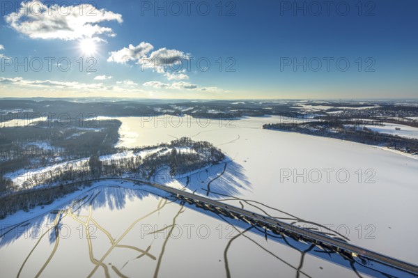 Aerial view, Möhnesee and Delecker Brücke, Delecke, Möhnesee, Sauerland, North Rhine-Westphalia, Germany, Arnsberger Straße, bridge, DE, Europe, distant view, backlight, aerial view, aerial photography, aerial photography, cracks in the ice, snow, sun, overview, bird's eye view, winter at Möhnesee, winter landscape, birds-eyes view, blue sky, overview