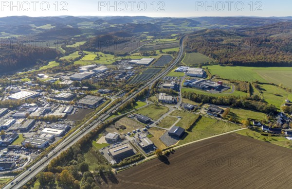 Aerial view, industrial area Enste with solar park at the motorway A46 m district Enste in Meschede, Sauerland, North Rhine-Westphalia, Germany, DE, Europe, commercial enterprises, commercial area, industrial park, commercial location, commercial use, hilly landscape, industrial area, industrial building, industrial site, aerial view, aerial photography, aerial photography, Meschede, photovoltaic, photovoltaic plant, solar, solar plant, solar roof, solar energy, solar park, overview, bird's-eye view, birds-eyes view, overview