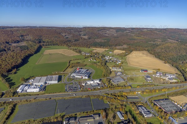 Aerial view, commercial area Enste with solar park at the motorway A46 in the district Enste in Meschede, Sauerland, North Rhine-Westphalia, Germany, DE, Europe, commercial enterprises, commercial area, commercial park, commercial location, commercial use, industrial area, industrial building, industrial location, aerial view, aerial photography, aerial photography, Meschede, photovoltaic, photovoltaic plant, solar, solar plant, solar roof, solar energy, solar park, overview, bird's-eye view, birds-eyes view, overview