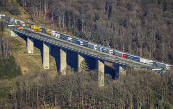 Aerial view, truck traffic jam on the Sterbecke viaduct in front of the closed Rahmede viaduct of the A45 Sauerlandlinie motorway in the Heedfeld district of Schalksmühle, Sauerland, North Rhine-Westphalia, Germany, A45, DE, Europe, truck traffic jam, aerial view, aerial photography, aerial photography, through road, Sauerlandlinie, Schalksmühle, damage to the steel structure, closure of the Rahmede viaduct, traffic jam, traffic jam, overview, traffic volume, traffic chaos, traffic infrastructure, traffic jam, bird's eye view, bird's eye view, lack of load-bearing capacity, closed Rahmede viaduct, dilapidated bridge, dilapidated bridges, overview