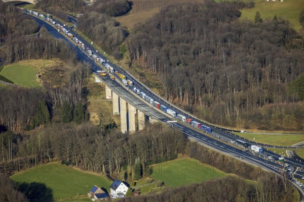 Aerial view, truck traffic jam on the Sterbecke viaduct in front of the closed Rahmede viaduct of the A45 Sauerlandlinie motorway in the Heedfeld district of Schalksmühle, Sauerland, North Rhine-Westphalia, Germany, A45, DE, Europe, truck traffic jam, aerial view, aerial photography, aerial photography, through road, Sauerlandlinie, Schalksmühle, damage to the steel structure, closure of the Rahmede viaduct, traffic jam, traffic jam, overview, traffic volume, traffic chaos, traffic infrastructure, traffic jam, bird's eye view, bird's eye view, lack of load-bearing capacity, closed Rahmede viaduct, dilapidated bridge, dilapidated bridges, overview