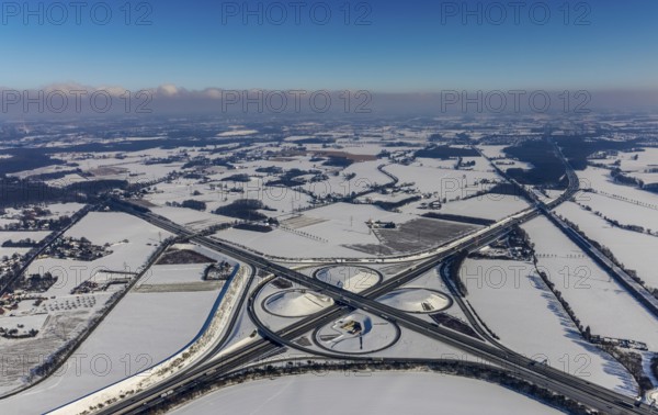 Aerial view, Kamener Kreuz in winter, A1 and A2, helicopter sculpture Yellow Angel, Kamen, Ruhr area, North Rhine-Westphalia, Germany, motorway A1, motorway A2, motorway junction, DE, Europe, distant view, clover shape, aerial view, aerial photography, aerial photography, snow, sculpture, overview, bird's-eye view, winter, birds-eyes view, overview