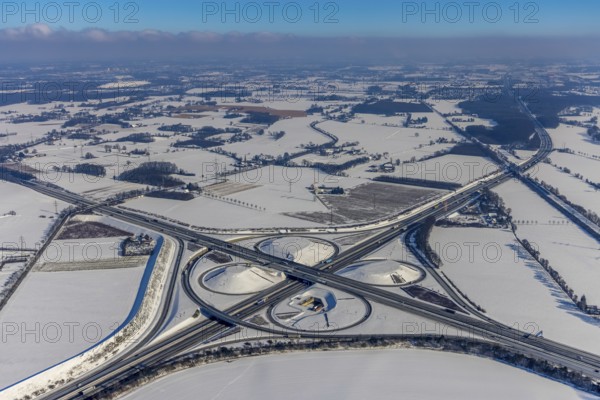 Aerial view, Kamener Kreuz in winter, A1 and A2, helicopter sculpture Yellow Angel, Kamen, Ruhr area, North Rhine-Westphalia, Germany, motorway A1, motorway A2, motorway junction, DE, Europe, distant view, clover shape, aerial view, aerial photography, aerial photography, snow, sculpture, overview, bird's-eye view, winter, birds-eyes view, overview