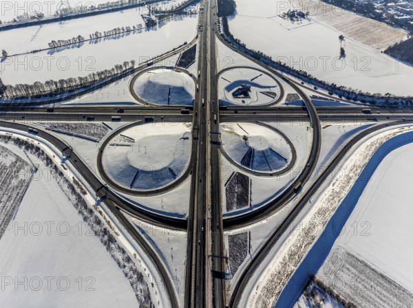 Aerial view, Kamen junction in winter, A1 and A2, helicopter sculpture Yellow Angel, Kamen, Ruhr area, North Rhine-Westphalia, Germany, motorway A1, motorway A2, motorway junction, DE, Europe, cloverleaf shape, aerial view, aerial photography, aerial photography, snow, sculpture, overview, bird's eye view, winter, birds-eyes view, overview