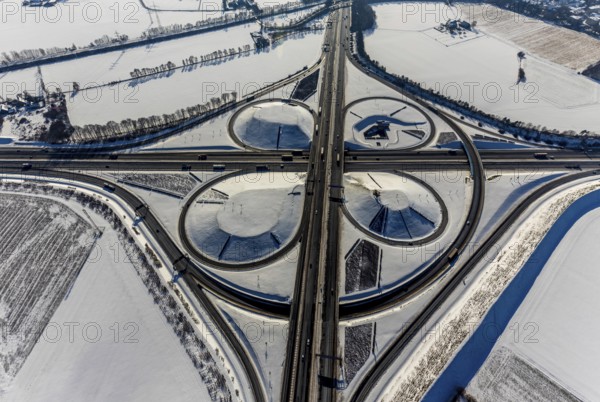 Aerial view, Kamen junction in winter, A1 and A2, helicopter sculpture Yellow Angel, Kamen, Ruhr area, North Rhine-Westphalia, Germany, motorway A1, motorway A2, motorway junction, DE, Europe, cloverleaf shape, aerial view, aerial photography, aerial photography, snow, sculpture, overview, bird's eye view, winter, birds-eyes view, overview