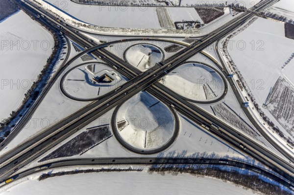 Aerial view, Kamen junction in winter, A1 and A2, helicopter sculpture Yellow Angel, Kamen, Ruhr area, North Rhine-Westphalia, Germany, motorway A1, motorway A2, motorway junction, DE, Europe, cloverleaf shape, aerial view, aerial photography, aerial photography, snow, sculpture, overview, bird's eye view, winter, birds-eyes view, overview