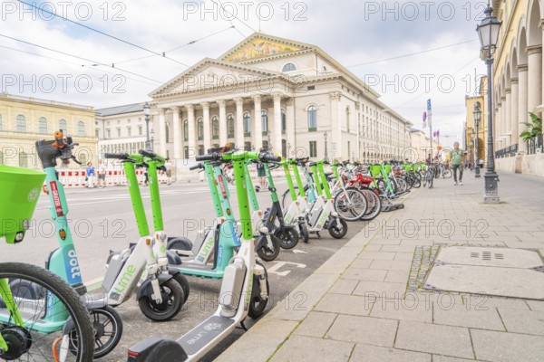 E-scooters and bicycles in front of a majestic building in the city of Munich, Munich, Germany