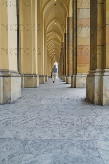 Long corridor with arches and columns, stone floor in a quiet atmosphere, Munich, Germany