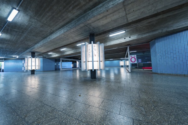 Empty underground station with blue walls and concrete, modern atmosphere, Munich, Germany