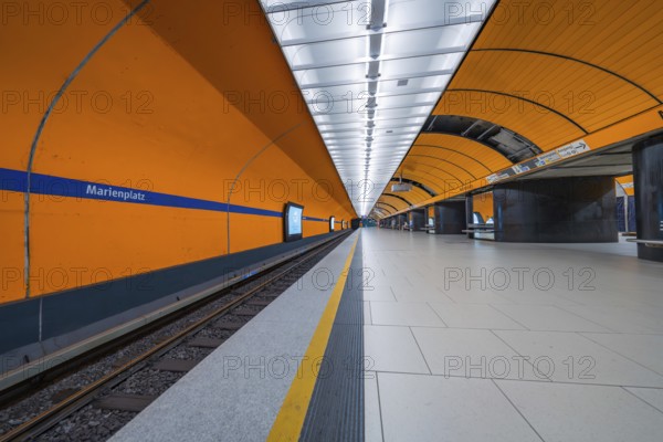 Futuristically designed underground station with bright orange walls and clear lines, Munich, Germany