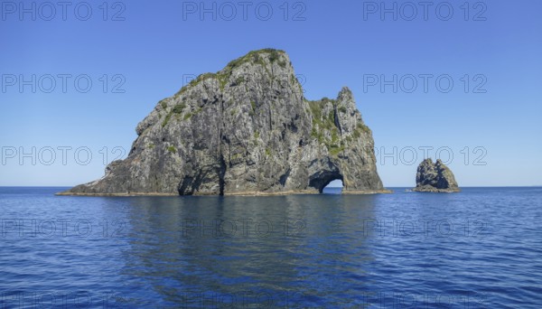 Sunny scenery showing a rock gate at the Bay of Islands, an area on the east coast of the Far North District of the North Island of New Zealand
