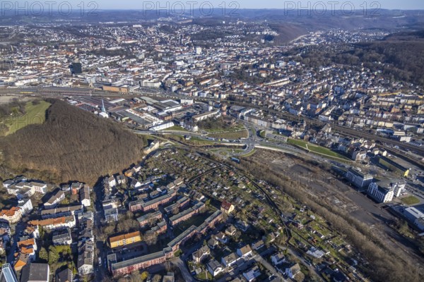Aerial view, railway station rear view, commercial area Wehringhauser Straße, forest area Postkopf, residential area Kuhlerkamp, Cunosiedlung, Wehringhausen, Hagen, Ruhr area, North Rhine-Westphalia, Germany, bridge, federal road B54, DE, through station, Europe, long-distance railway station, property tax, freight traffic, real estate, aerial view, aerial photography, aerial photography, passenger traffic, regional railway station, suburban railway station, overview, bird's-eye view, housing estate, housing and living, residential area, residential buildings, housing quality, residential neighbourhood, housing estate, birds-eyes view, overview