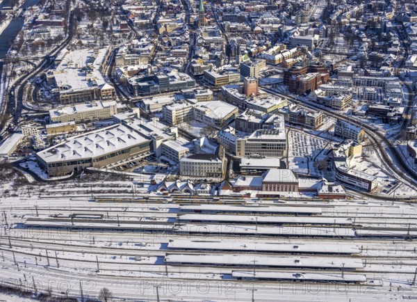 Aerial view, Hamm main station, tracks and platforms in the snow, winter, city centre, Heinrich-von-Kleist-Forum, city library, centre, Hamm, Ruhr area, North Rhine-Westphalia, Germany, DE, Europe, aerial view, aerial photography, aerial photography, snow, overview, bird's-eye view, birds-eyes, view, overview, main station, Heinrich-vin-Kleist-Forum, train traffic, railway traffic, traffic connection, travel, holiday, federal railway, German, railway, tracks, trains, transport, traffic, rails, books, media, reading, audiobooks, information, fiction, knowledge, culture, shopping