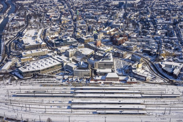 Aerial view, Hamm main station, tracks and platforms in the snow, winter, city centre, Heinrich-von-Kleist-Forum, city library, centre, Hamm, Ruhr area, North Rhine-Westphalia, Germany, DE, Europe, aerial view, aerial photography, aerial photography, snow, overview, bird's-eye view, birds-eyes, view, overview, main station, Heinrich-vin-Kleist-Forum, train traffic, railway traffic, traffic connection, travel, holiday, federal railway, German, railway, tracks, trains, transport, traffic, rails, books, media, reading, audiobooks, information, fiction, knowledge, culture, shopping