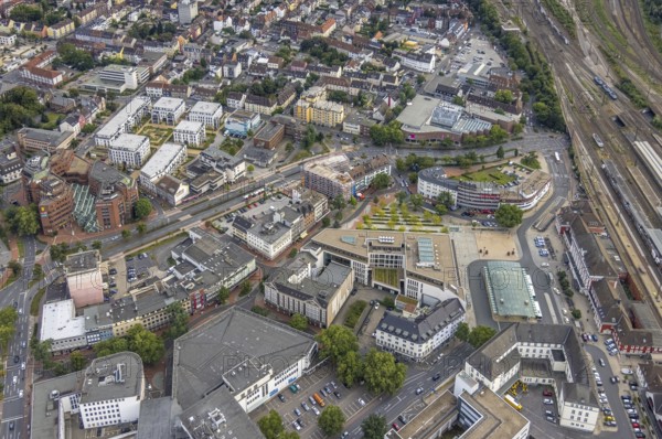 Aerial view, city centre view city with Platz der Deutschen Einheit at Hamm main station as well as construction site and new residential building on the former site of the Kippâ'¬â¢n in Bahnhofstraße in Mitte, Hamm, Ruhr area, North Rhine-Westphalia, Germany, Bahnhofstraße, construction work, construction area, construction site, building plots, construction project, construction site, bunker, DE, Europe, commercial buildings, high bunker, aerial view, aerial photography, aerial photography, new construction, square, overview, bird's-eye view, overview, city centre view City with Platz der Deutschen Einheit at Hamm main station as well as construction site and new residential building on the former site of the Kipp'™n in Bahnhofstraße in Mitte