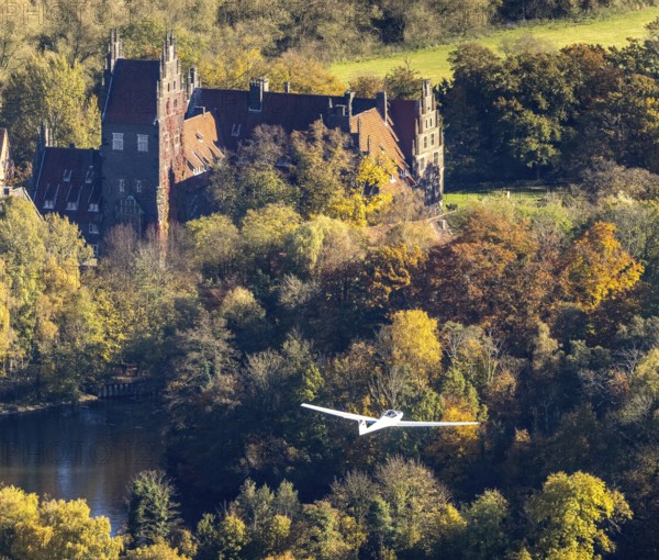 Aerial photo, motor glider at Heessen Castle in the autumnal forest in the Heessen district of Hamm, Ruhr area, North Rhine-Westphalia, Germany, education, educational institution, castle, DE, Europe, aircraft, Hamm, autumn colours, educational institute, aerial photo, aerial photography, aerial photography, motor glider, castle, castle complex, school, overview, bird's-eye view, overview