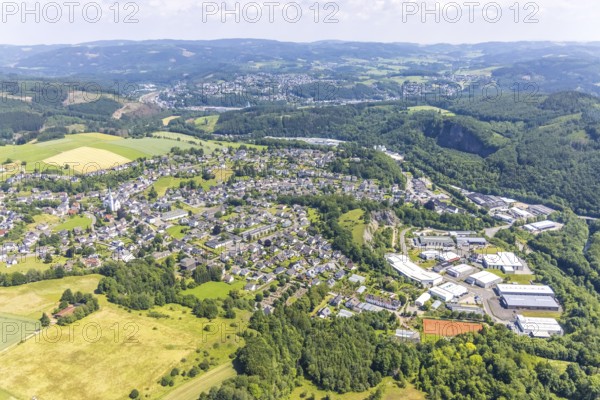 Aerial view, commercial area Zum Elberskamp and view of the village, St. Antonius Einsiedler, Heggen primary school, Heggen, Finnentrop, Sauerland, North Rhine-Westphalia, Germany, place of worship, education, educational institution, DE, Europe, commercial enterprises, commercial area, industrial estate, industrial park, commercial site, commercial use, religious community, place of worship, primary school, sacred site, hilly landscape, industrial area, industrial building, industrial site, church, parish, denomination, educational institute, aerial view, aerial photography, aerial photography, religion, religious site, school, overview, bird's-eye view, forest area, birds-eyes view, overview