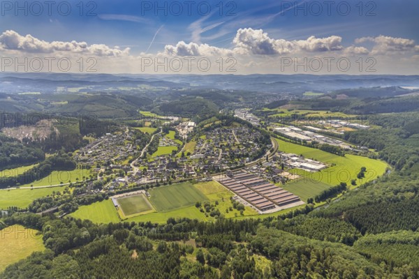 Aerial view, Lenhausen sports ground and Feinblech Systeme GmbH, hilly landscape and view of Lenhausen, industrial estate Industriestraße and Frielentrop III Kalkofenstraße, Finnentrop, Sauerland, North Rhine-Westphalia, Germany, DE, Europe, distant view, football pitch, commercial enterprises, commercial area, commercial site, commercial use, property tax, hilly landscape, real estate, industrial area, industrial building, industrial site, aerial view, aerial photography, aerial photography, sports, sports facilities, sports field, sports facility, overview, bird's-eye view, residential area, residential area, residential buildings, residential quality, cloud formation, birds-eyes view, overview