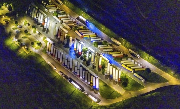 Aerial view, motorway service area Resser Mark, Resse, Gelsenkirchen, Ruhr area, North Rhine-Westphalia, Germany, motorway A2, DE, twilight photography, Europe, shapes and colours, truck parking, light pollution, aerial photography, aerial photography, night, night photography, night flight, parking, road traffic, overview, bird's eye view, illuminated road traffic, birds-eyes view, nightflight, overview