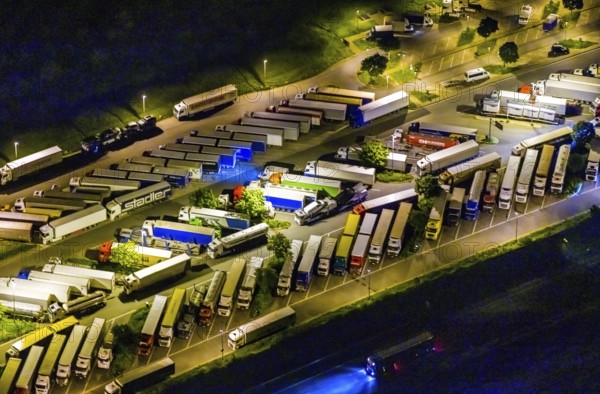 Aerial view, motorway service area Resser Mark, Resse, Gelsenkirchen, Ruhr area, North Rhine-Westphalia, Germany, motorway A2, DE, twilight photography, Europe, shapes and colours, truck parking, light pollution, aerial photography, aerial photography, night, night photography, night flight, parking, road traffic, overview, bird's eye view, illuminated road traffic, birds-eyes view, nightflight, overview