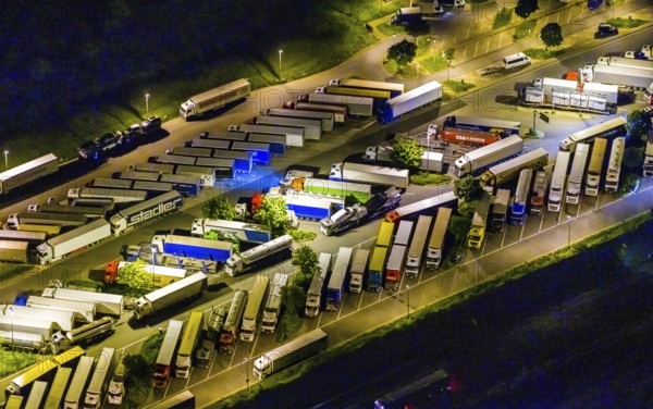 Aerial view, motorway service area Resser Mark, Resse, Gelsenkirchen, Ruhr area, North Rhine-Westphalia, Germany, motorway A2, DE, twilight photography, Europe, shapes and colours, truck parking, light pollution, aerial photography, aerial photography, night, night photography, night flight, parking, road traffic, overview, bird's eye view, illuminated road traffic, birds-eyes view, nightflight, overview