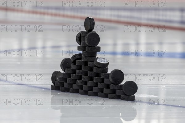 Ice hockey symbol image: Close-up of pucks stacked on the ice for the warm-up game