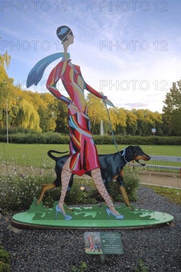 Sculpture Lady with Doberman by Carolin Okon 2017, modern art, colourful elegant female figure walking a dog, walk with dog, dog figure, walking, sports park, Apolda, Thuringia, Germany