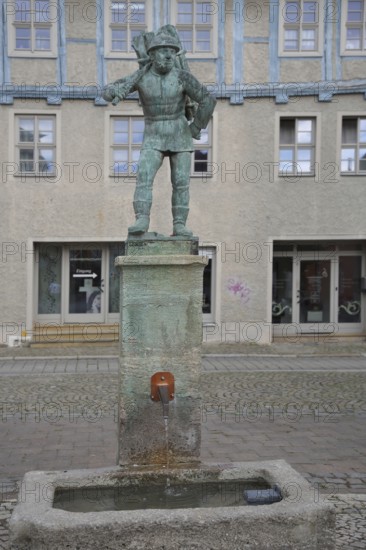 Wood carrier by Bernhard Frydag, 1914, male figure carrying basket with wood on his back, symbol for forestry, logging, lumberjack, wood, fountain, wood carrier fountain, wood market, Aschersleben, Harz, Saxony-Anhalt, Germany