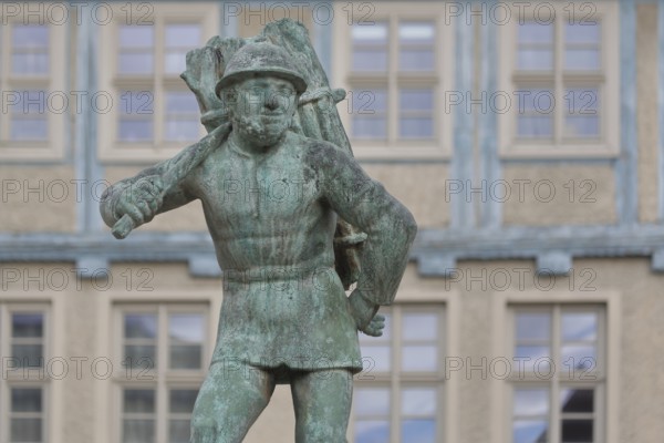 Wood carrier by Bernhard Frydag, 1914, male figure carrying basket with wood on his back, symbol for forestry, logging, lumberjack, wood, fountain, wood carrier fountain, wood market, Aschersleben, Harz, Saxony-Anhalt, Germany