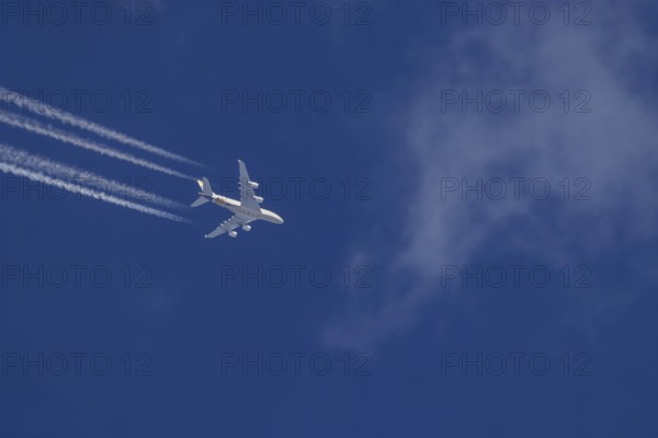 Aircraft in the sky at cruising altitude. Airbus A380 of the airline Ethihad en route to Abu Dhabi. Contrails in the sky. These artificial clouds are created from the exhaust fumes of aeroplanes. But there are also conspiracy theory myths. Stuttgart, Baden-Württemberg, Germany