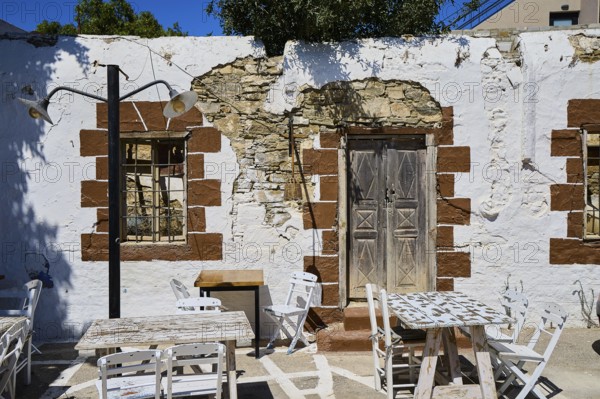 Taverna, Rustic wall with wooden doors, lights and weatherboarded brickwork, Kattavia village, southern tip of Rhodes, Rhodes, Dodecanese, Greek Islands, Greece