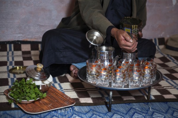 Moroccan man pouring traditional green tea into the kettle