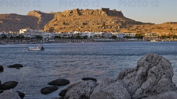 Feraklos fortress, coastal town with a castle above the evening sky and rocks on the shore, bay, Charaki, Haraki, east coast of Rhodes, Rhodes, Dodecanese, Greek Islands, Greece