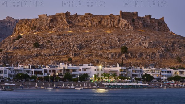 Feraklos fortress, Old castle at dusk with illuminated town and calm sea below, bay, Charaki, Haraki, east coast Rhodes, Rhodes, Dodecanese, Greek Islands, Greece
