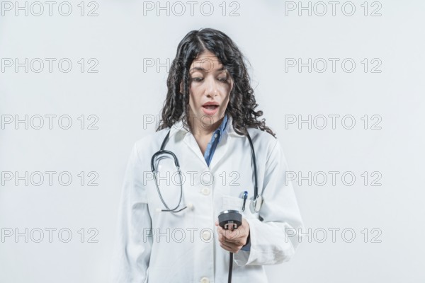 Surprised female doctor with blood pressure monitor isolated. Surprised doctor with blood pressure monitor