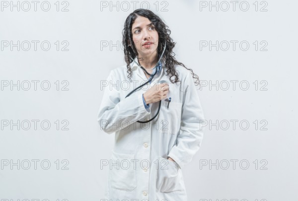 Doctor listening to her heart with stethoscope, isolated. Female doctor with stethoscope on her chest listening to her heart