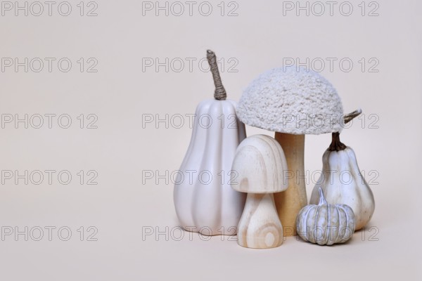 Decorative mushroom and pumpkin ornaments on beige background with copy space. Autumn seasonal composition